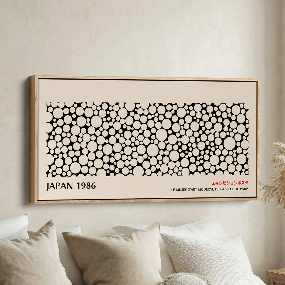 Japanese wall art black and white dot pattern horizontal canvas print in a wood floating frame displayed in a living room