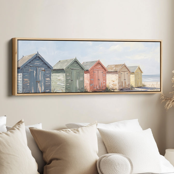 Above Bed Wall Art Panoramic Pastel Beach Huts by the Sea canvas in an oak frame, above the bed