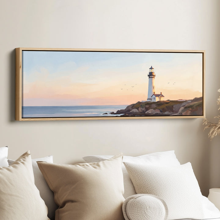 Lighthouse at Sunset Panoramic Wall Art for Above Couch canvas in an oak frame, above the bed