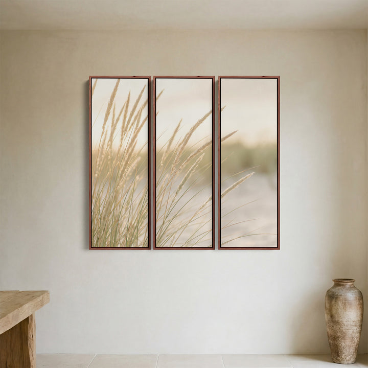 Verticale drieluik-wandkunst voor de woonkamer met een lage zon achter duingras