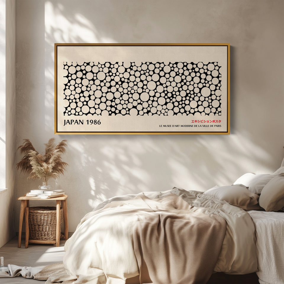 Japanese wall art black and white dot pattern horizontal canvas print in a gold floating frame displayed in a living room
