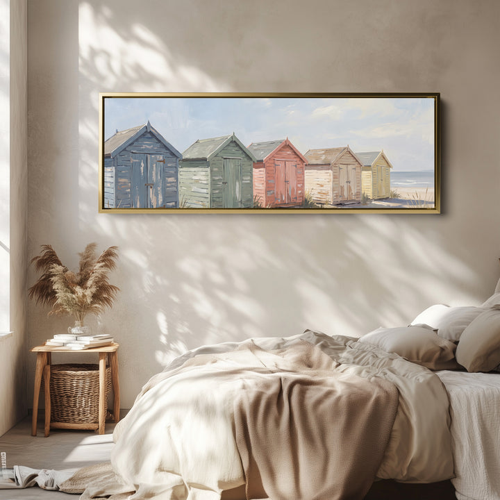 Above Bed Wall Art Panoramic Pastel Beach Huts by the Sea wall art in a gold frame, above the bed