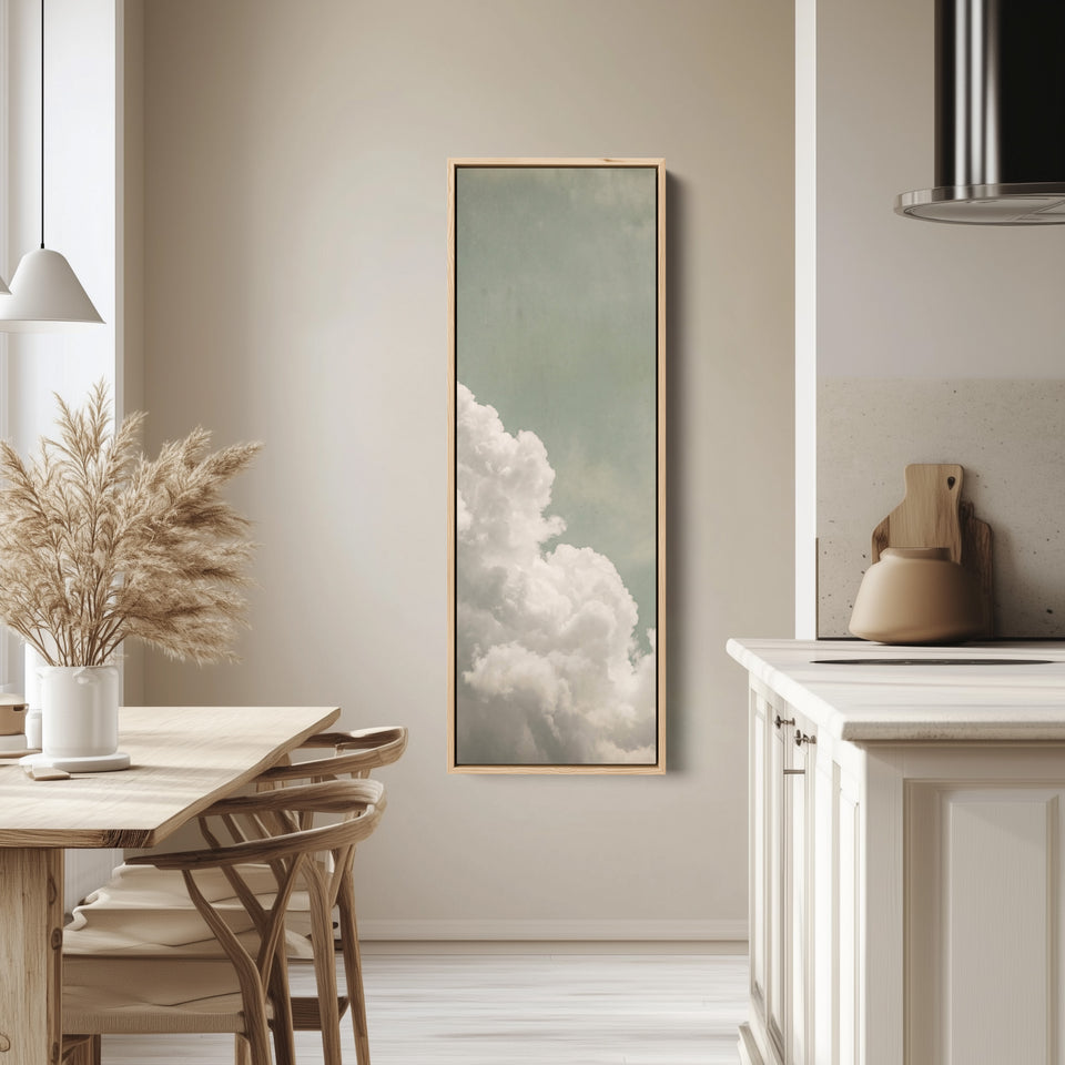 White Clouds on a Sage Sky Vertical Wall Art for Living Room tall canvas in an oak frame, hung in a bright kitchen