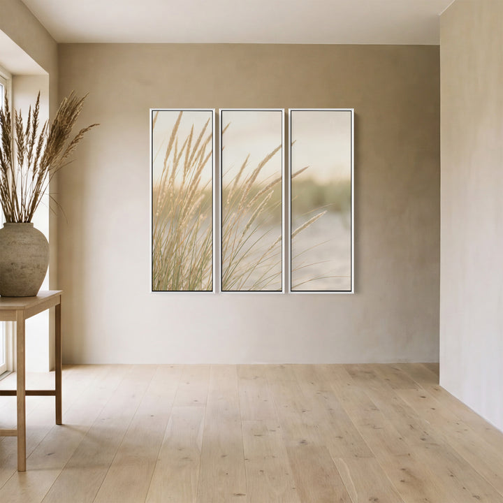 Verticale drieluik-wandkunst voor de woonkamer met een lage zon achter duingras